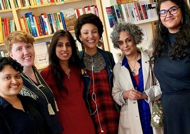 Arundhati Roy standing in lighthouse surrounded by Lighthouse keepers